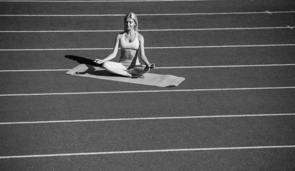 スポーツウェアを着たスポーツウェアの女性トレーニングフィットネスや瞑想の前に陸上競技場でヨガを練習 — ストック写真