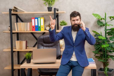 Bir fikrim var. Müdür, cep telefonuyla konuşup parmağını kaldırdı. Bir fikrim var. Evreka. Mobil iletişim. İş çağrısı.