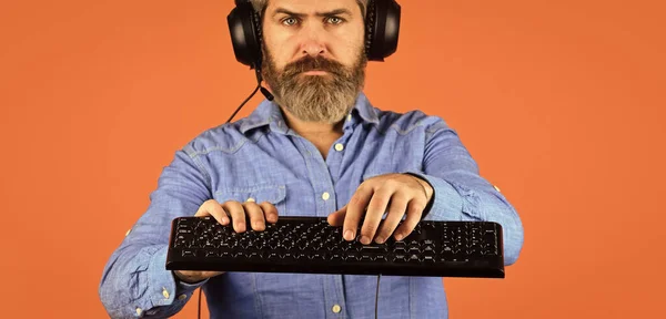 Run any modern game. Play computer games. Man bearded hipster gamer headphones and keyboard. Gaming PC build guide. Graphics settings pushed to limit. Gaming addiction. Online gaming. Modern leisure.