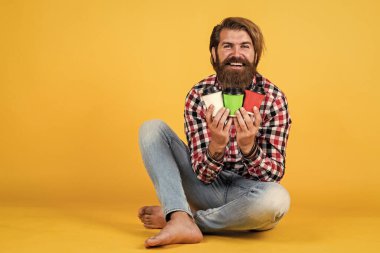 Neyi seçeceğimi. Enerjik, sıcak içecek. İlham almak için kahve lazım. Mutlu sakallı adam sabah kahvesini içiyor. Adam kağıt bardaktan sıcak çay içiyor. Günaydın..