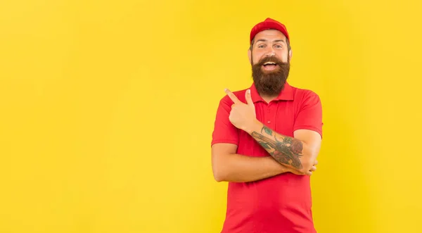 Happy Bearded Guy Casual Red Cap Tshirt Pointing Finger Aside — Foto Stock