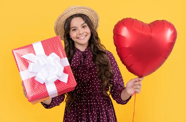 Smiling Teen Girl Red Heart Balloon Present Box Yellow Background — стоковое фото