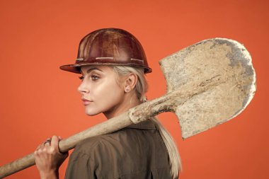 Hadi çalışalım. İşçi bayramı. Klimalı ve kasklı kadın. Kadın müteahhit kürek tutuyor. Bina ve inşaat. Bayan mimar. Turuncu arka planda mühendis. Ustabaşı kız emniyet başlığı takıyor.