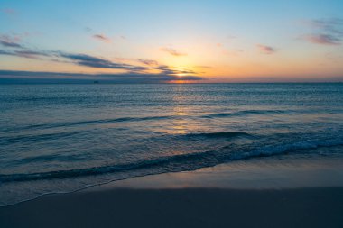 Yaz sahilinde deniz suyuyla güzel bir bali gün batımı..