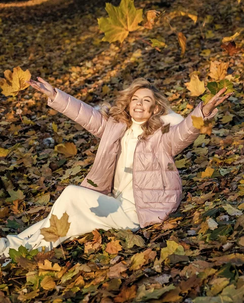 Feeling free and relaxed. nature beauty. beautiful blonde woman in coat. autumn fashion and beauty. pretty girl has long curly blond hair. lady in fall padded jacket in autumn forest. fallen leaves.