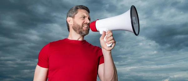 man in red shirt shout in loudspeaker on sky background. advertisement.