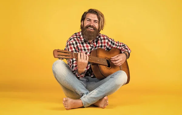 his new song. relax with favorite music. guy with guitar performing song. Guitar player on yellow background. Cheerful guitarist. charismatic mature man playing guitar while sitting.