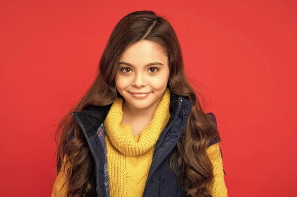 Kış Mevsiminde Kıvırcık Saçlı Gülümseyen Çocuk Kırmızı Arka Planda Yelek — Stok fotoğraf