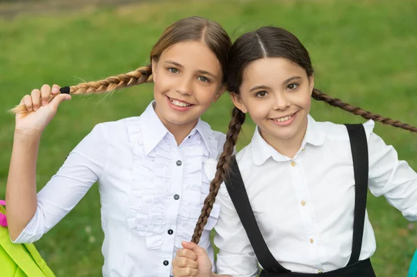 schoolgirl portrait. two happy braided teen children schoolgirls outdoor. friendship of schoolgirls.