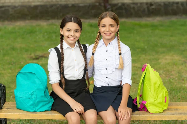 back to school. two glad teen children after school outdoor. friendship of school girls.