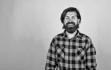 Mavi arka planda olgun bir berber. Erkeklik ve karizma. Sıradan moda tarzı. Modern görünümlü sakallı hippi. Kuaför konsepti. Bıyıklı vahşi yakışıklı adam. Kopyalama alanı.