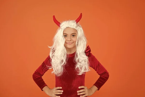 happy halloween. smiling child in devil horns. kid has long white hair wig. childhood happiness. teen girl ready to celebrate costume party. funny red imp horns. devil costume.