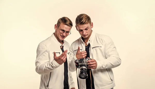 twin brothers men look alike use vintage photo camera, photographing.