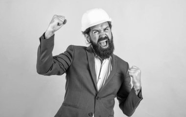 Kasklı, sakallı ve bıyıklı başarılı bir adam inşaat alanında iş adamı gibi görünüyor, başarıyı kutluyor..