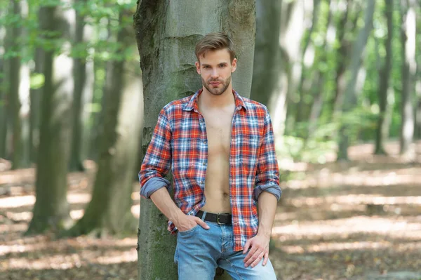Unshaven Lumbersexual Man Unbuttoned Lumberjack Shirt Standing Tree Forest Background — Fotografia de Stock