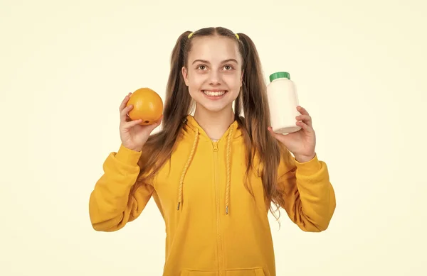 vitamin c. organic food supplement. choice between natural products and pills. presenting vitamin product. child with orange flavored pill. effervescent tablet for kids. happy girl hold multivitamin.