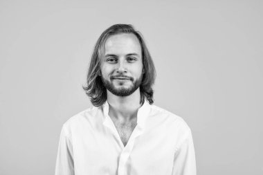 Uzun saçlı, traşsız bir adam. Gülümseyen mutlu adam beyaz ofis gömleği giyiyor. Kendine güvenen ve karizmatik bir iş adamı. Sakallı neşeli menajer. Erkek güzellik ve moda. başarı.