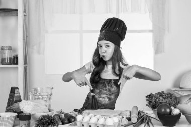 Yemek yiyorum. Çocuk aşçı üniforması giyiyor. Sadece sağlıklı ürünler kullanın. Vitamin dolu. Diyet yapıyorum. Genç fırıncı çocuk mutfakta yemek hazırlıyor. Akşam yemeği için yemek pişirmek. Mutlu çocukluk gelişimi.