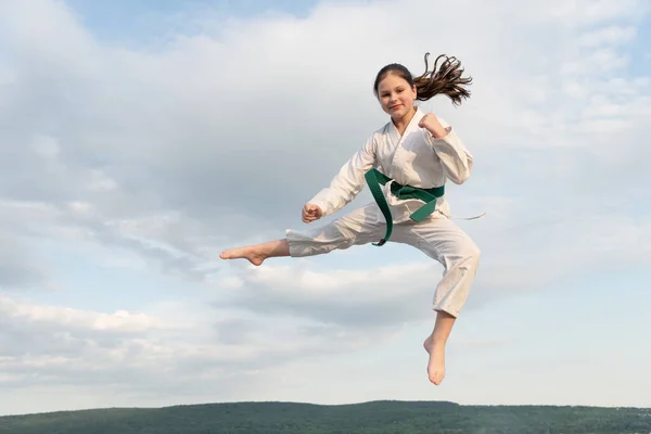 judo concept. teen girl practicing judo. girl judo fighter on sky background.
