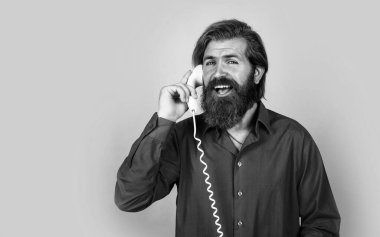 Tişörtlü, sakallı, vahşi beyaz hipster. Retro telefonda konuş, iletişim kur.