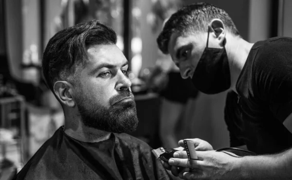 Perfect beard. hipster. male barber care. bearded man at hairdresser chair in salon. beauty and fashion. hair and beard styling. brutal guy with barbershop professional master use electric shaver.