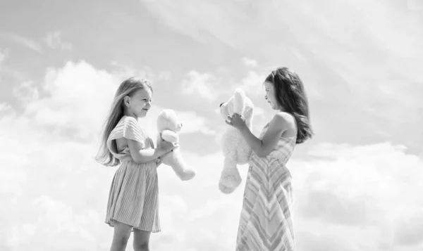 若く美しい 友情や姉妹関係です 幸せな子供時代 空を背景にかわいい子供たち 夏の季節の天気 熊と遊べ おもちゃのきれいな10代の女の子の姉妹 キッズファッションスタイル — ストック写真