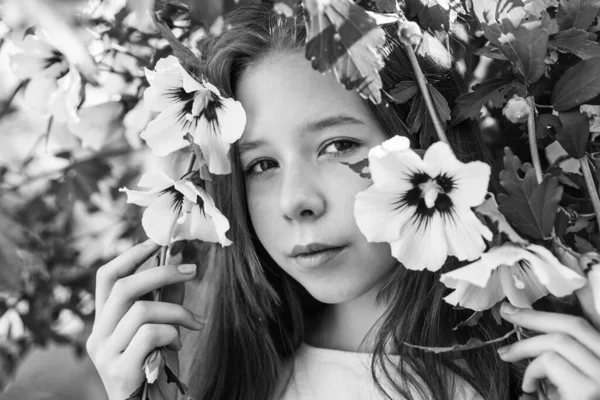 幸せな子供時代 屋外の木の開花時に明るい子供 休暇の時間だ 夏のファッションと美しさ ハイビスカスの茂みの花を持つ美しい10代の女の子 子供の春ファッションスタイル — ストック写真