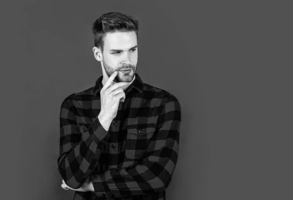 stylish male wear casual clothes. bearded man with bristle on unshaven face. fashion and beauty. barbershop concept. mens wear. young handsome guy in red checkered shirt. copy space.