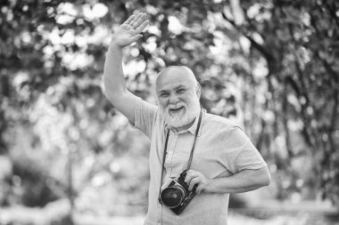 Duygular ve fotoğraflar. Hobi ve boş zaman. Bahar bahçesinde deneyimli bir fotoğrafçı. Kıdemli adam doğada ateş eder. Dışarıdaki kameraman. Doğayı çeken fotoğrafçı. Ömür boyu hatıralar oluşturuluyor.