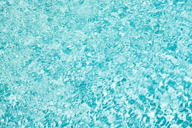 turquoise color background of swimming pool water with ripples in summer resort.