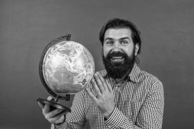 Kareli gömlekli mutlu sakallı adam coğrafya ve coğrafya okulu eğitimine bakıyor..