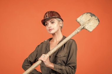 Küçük bir mola. Turuncu arka planda mühendis. Ustabaşı kız güvenlik kaskı takıyor. İşçi bayramı. Klimalı ve kasklı kadın. Kadın müteahhit kürek tutuyor. Bina ve inşaat. Bayan mimar..