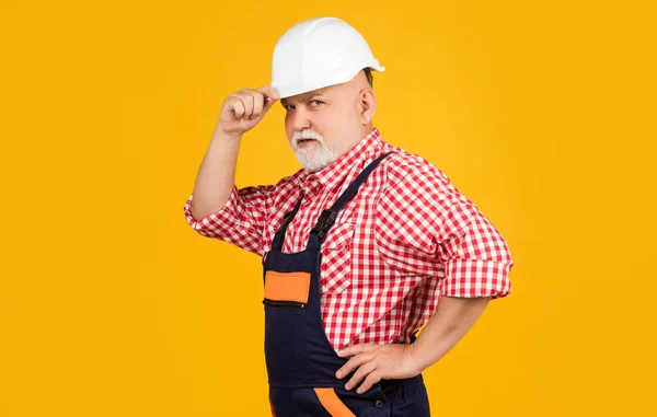 Serious Aged Man Builder Helmet Yellow Background — Zdjęcie stockowe