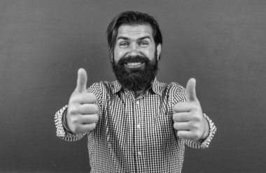 Öğretmenler günün kutlu olsun. Başparmağını kaldır. Sakallı vahşi adam kostüm giyiyor. gayri resmi eğitim. Erkek öğrenci ders sırasında sınıfta oturur. Sınavı geç. Konuyu öğrenmek. Okula geri dön..