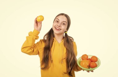 Mutlu çocuk beyaz, organik vitaminli limon meyvesi tutuyor..