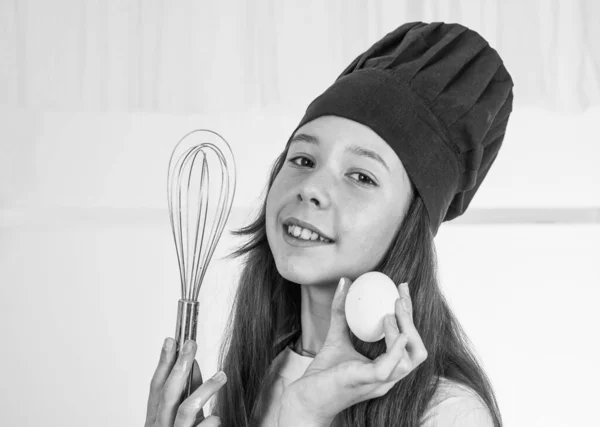 At work. young baker kid preparing meal in kitchen. cooking food for dinner. happy childhood development. child wearing cook uniform. use healthy products only. full of vitamins. dieting.