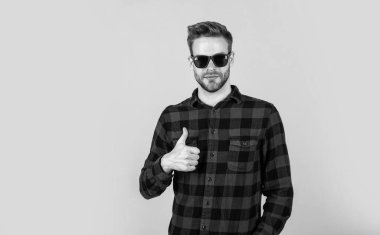 Bu mükemmel. İyi bakımlı bir saç stili. Erkek güzellik ve moda. Sakallı adam için kareli gömlek. Tıraşsız, güneş gözlüklü yakışıklı adam. Kuaför konsepti. Genç ve kendinden emin.
