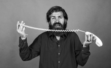 Olgun sakallı adam modaya uygun görünüyor. Retro telefonu tut, konuş..