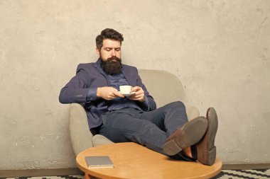 Rahatlatıcı eleman çay içer dinlenme koltuğuna oturur, çay molası verir..