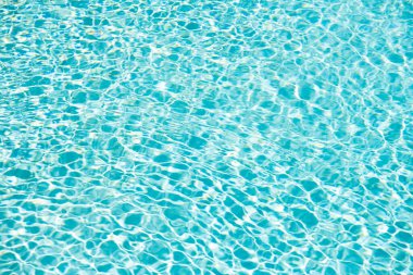 blue color background of swimming pool water with ripples on summer vacation.