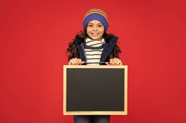発表と広告です 冬の売り上げ ハッピー キッドはブラックボードを持ってる 10代の少女がコピースペースで黒板を持ってる 子供は学校に戻り — ストック写真