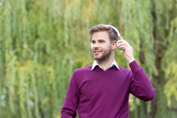 young handsome guy listen music in headphones outdoor. copy space.