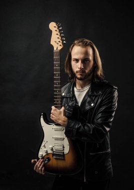 Ürün sunumu. müzik enstrümanı. Sakallı rockçı. Uzun saçlı bir adam elektro gitar çalıyor. Rock müzik tarzı. müzisyen gitarist. Rock müziğini ustaca çalmak. şık çılgın adam..