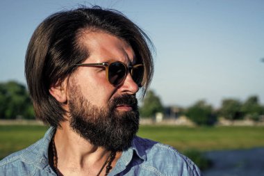 Kendine güvenen ve yakışıklı vahşi bir adam. Berber dükkanı. Erkek güzellik ve moda. Ciddi insani duygular. Sıradan tarzını seviyor. Sakallı adam. Saç ve sakal bakımı. Boşluğu kopyala.