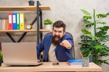 Shaking fist at somebody. Angry boss yelling at office desk. Work stress. Between anger and stress.