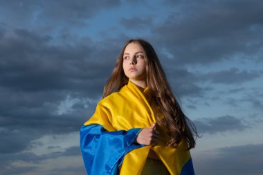 patriotic teen ukrainian kid with national flag of ukraine.