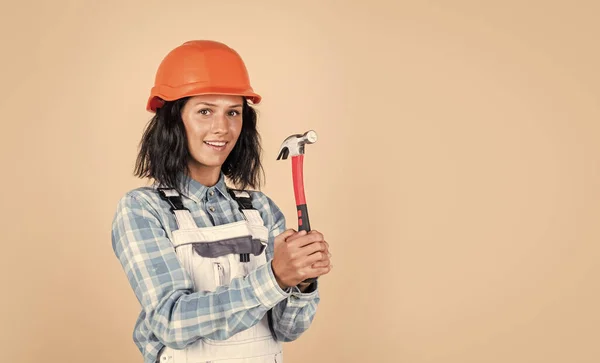 それは良い基盤から始まります 修理と改修です 女性は防護ヘルメットを着用する 建設現場でハードハットの女の子のビルダー エンジニアはハンマーを持ってる ベージュを背景に若い女性労働者が — ストック写真