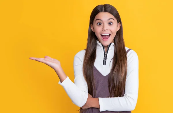 Amazed Child Long Hair Yellow Background Presenting Product — 스톡 사진
