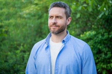 Portrait of handsome professional guy in blue shirt natural background.