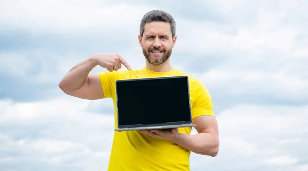 Man Presenting Computer Sky Background Copy Space — Stockfoto